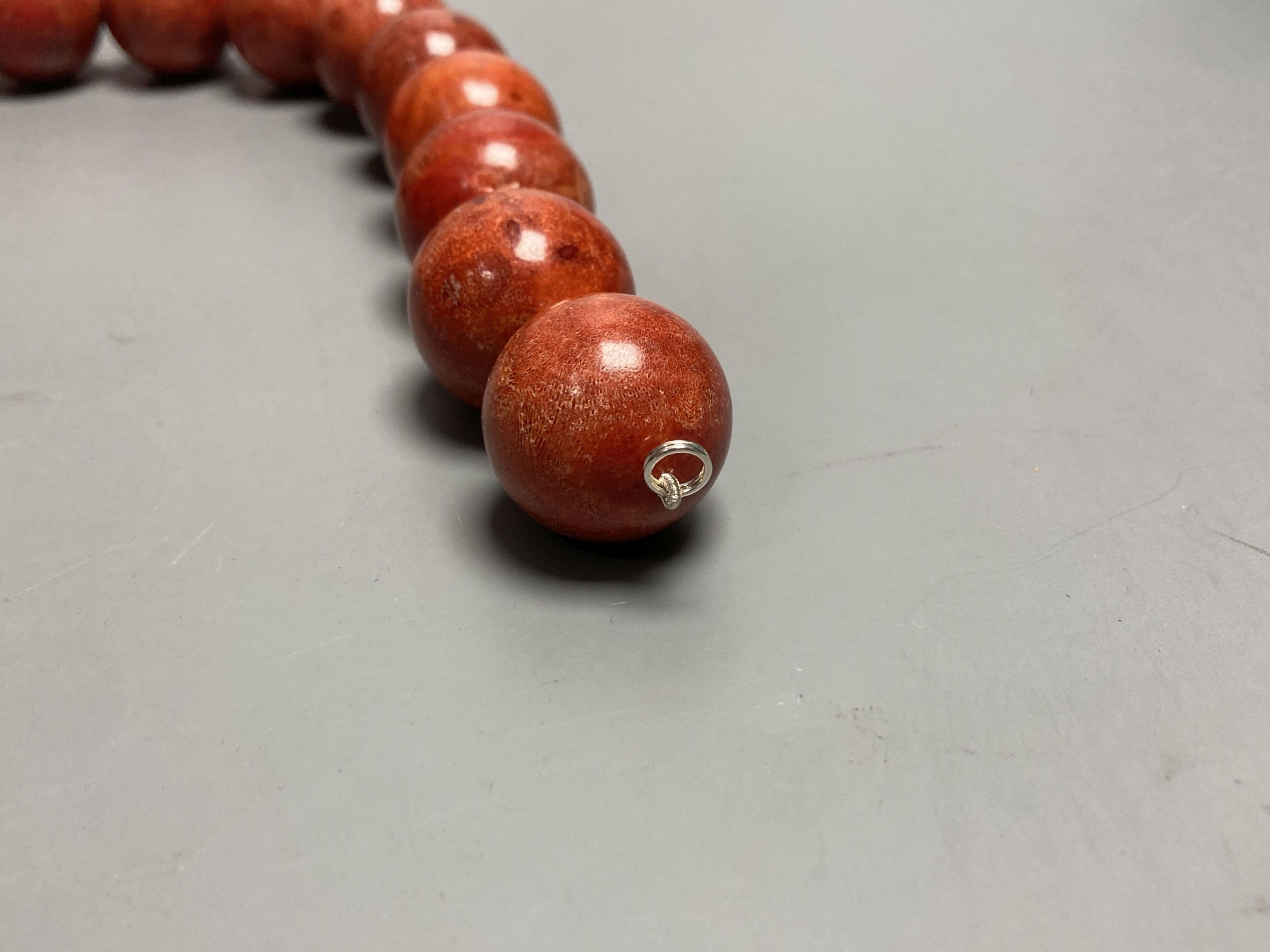 A large single strand circular stained? coral bead necklace, no clasp, 43cm, gross 267 grams.